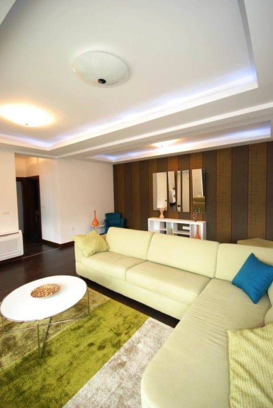 Modernes Wohnzimmer mit Ecksofa und Deckenbeleuchtung in einer Wohnanlage, Kostanica, Montenegro.
