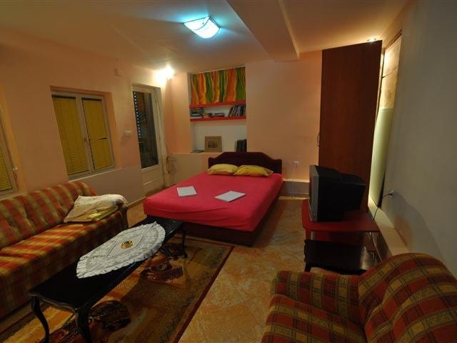 Living room with a double bed and soft furniture in a house for sale in Petrovac, Montenegro.