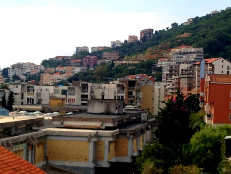 Panoramski pogled na stambene zgrade i zelene brežuljke u gradu Budvi, Crna Gora, pogled na gradsku izgradnju i pejzaž.