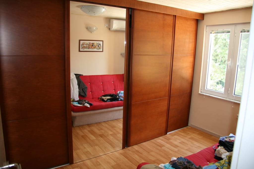 Salon avec canapé rouge et placard intégré dans un appartement à vendre, Radovići, Monténégro.