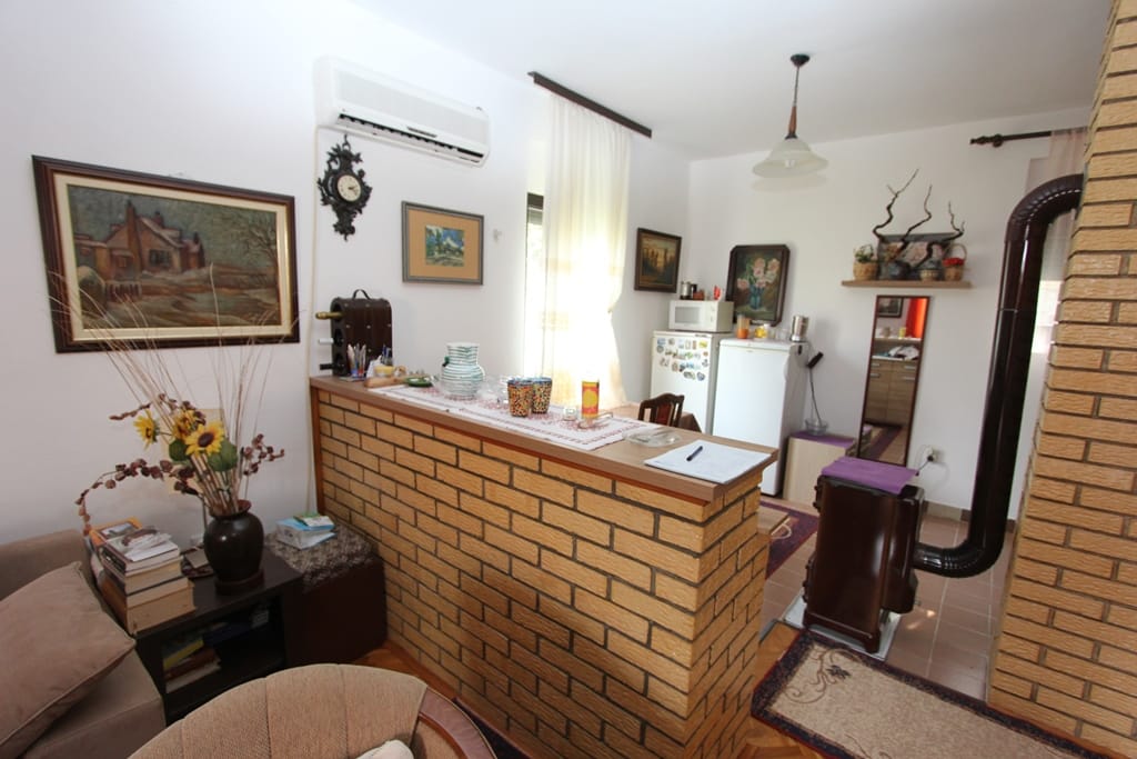 Salon z ceglaną ladą barową i piecem opalanym drewnem w domu na sprzedaż, Prčanj, Czarnogóra.