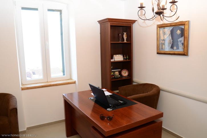 Arbeitszimmer mit Holztisch, Regal und Sesseln in einer Wohnung, Herceg Novi, Montenegro.