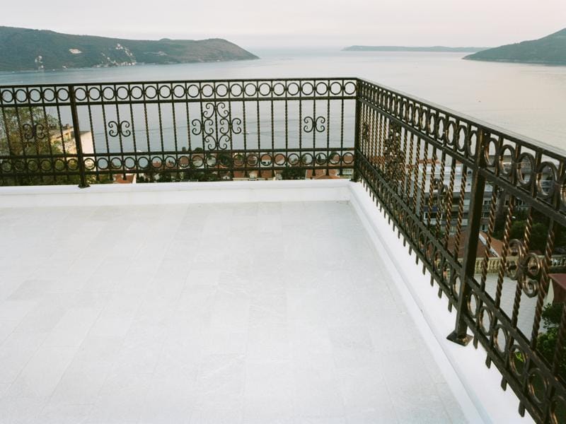 Terrasse spacieuse avec garde-corps en fer forgé et vue panoramique sur la mer et les montagnes, villa à Herceg Novi, Monténégro.