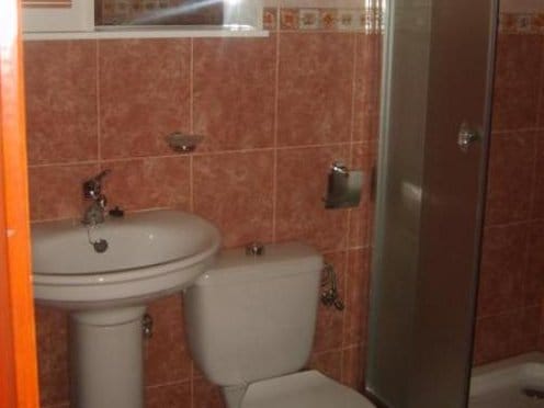Kupatilo sa tuš kabinom i keramičkim pločicama u stanu na prodaju, grad Sutomore, Crna Gora.