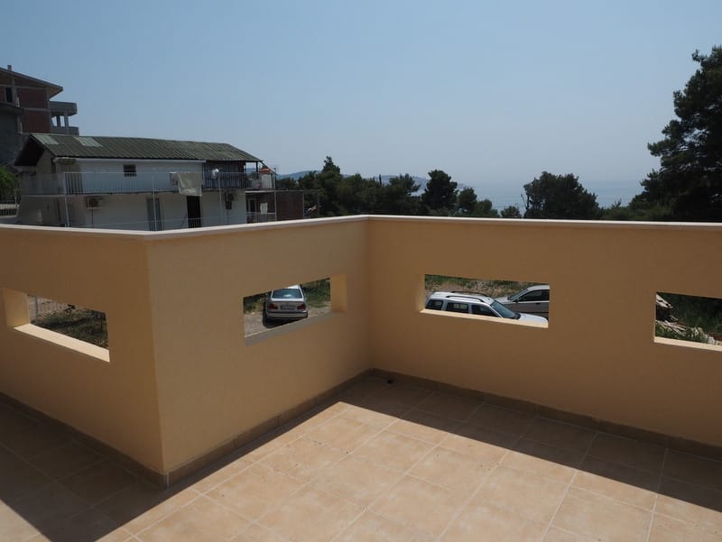 Geräumige offene Terrasse mit Fliesenbelag in einem Haus in Bar, Montenegro, mit Blick auf das Meer und die Umgebung.