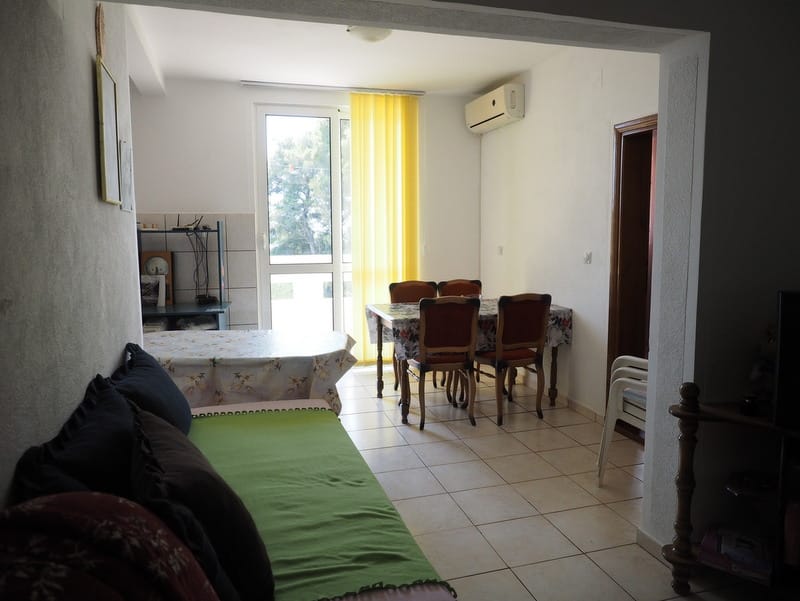 Wohnzimmer mit Essbereich in einem Haus in Bar, Montenegro: heller Raum mit Fliesen, Möbeln und Zugang zur Terrasse.
