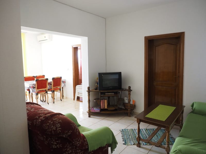Wohnzimmer mit Polstermöbeln und Essbereich in einem Haus zum Verkauf, Stadt Bar, Montenegro. Helles Interieur mit Fliesen.