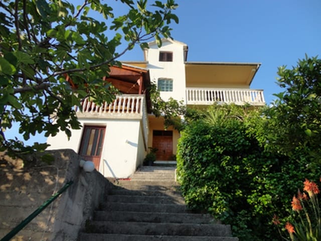 Dreistöckiges Haus in Herceg Novi, Montenegro: Blick auf die Fassade mit Terrassen, Steintreppe und grünem Garten.