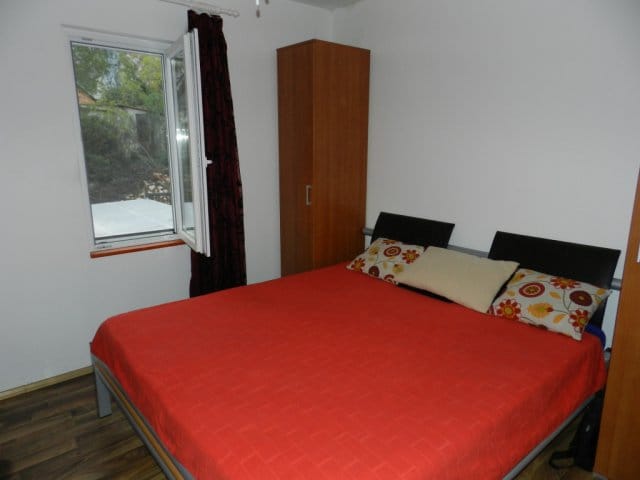 Schlafzimmer mit Doppelbett, Kleiderschrank und Fenster in einem Haus zum Verkauf in Bar, Montenegro.