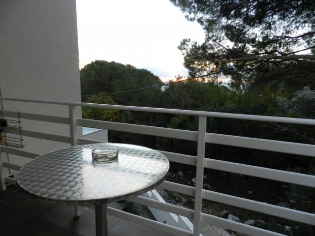 Blick vom Balkon eines Hauses in Bar, Montenegro: ein Metalltisch und Panoramablick auf einen grünen Garten und Bäume.