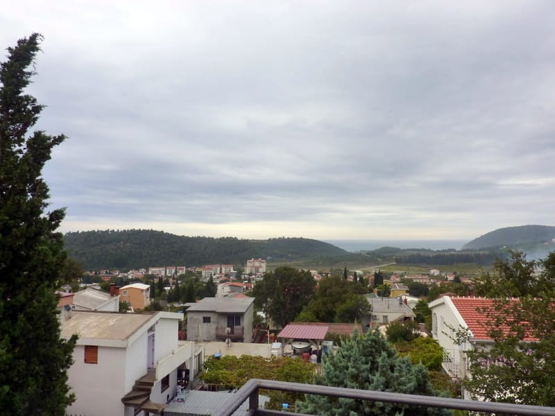Panoramski pogled sa balkona kuće u Sutomoru, Crna Gora: zeleni brežuljci, mediteranska gradnja i morski horizont.