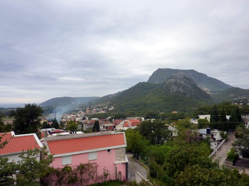 Panoramski pogled na planine i grad Sutomore u Crnoj Gori sa terase privatne kuće sa crvenim crepom.