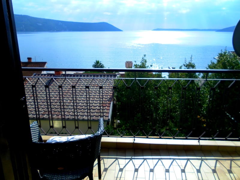 Balkon mit Rattanmöbeln und Panoramablick auf das Meer in einem Haus, Herceg Novi, Montenegro.