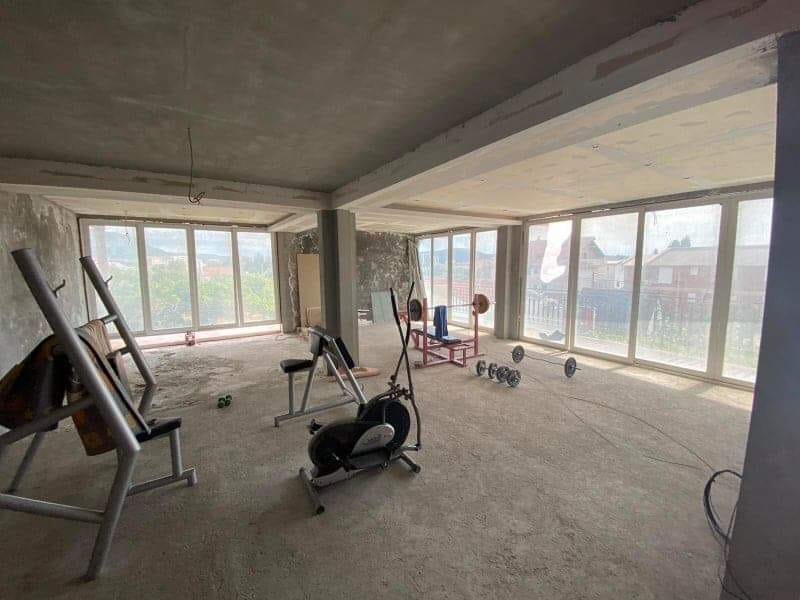 Prostrana prostorija za teretanu u kući u Šušnju, Crna Gora, sa panoramskim prozorima i spravama za vežbanje, bez završne obrade.