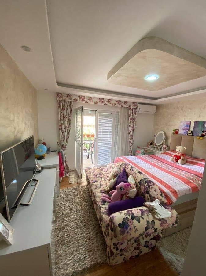 Ugodna spavaća soba sa bračnim krevetom i izlazom na balkon u kući, Šušanj, Crna Gora. Svetao enterijer sa nameštajem.