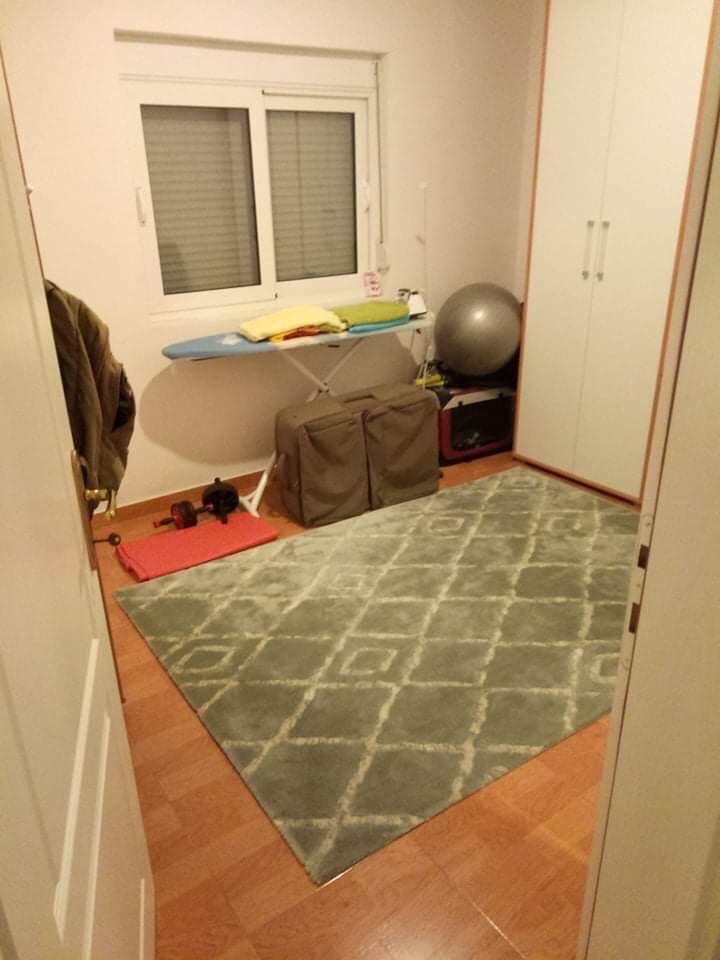 Mala soba sa belim ormarom i tepihom u kući u Šušnju, Crna Gora. Unutra su daska za peglanje i sportska oprema.