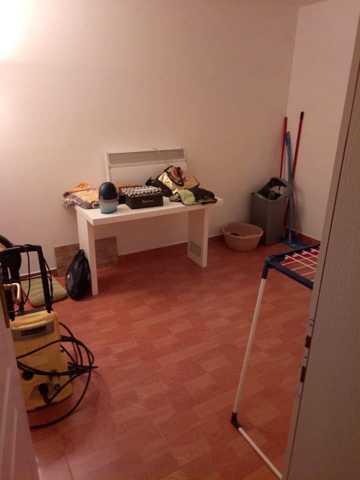 Ekonomska prostorija u kući u Šušnju, Crna Gora: beli nameštaj, pločice na podu i pribor za čišćenje.