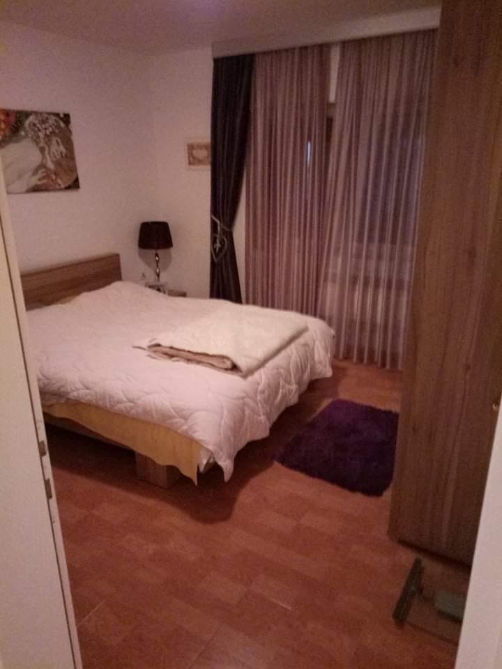 Ugodna spavaća soba sa bračnim krevetom i ormarom u kući, Šušanj, Crna Gora. Svetao enterijer sa pločicama na podu.