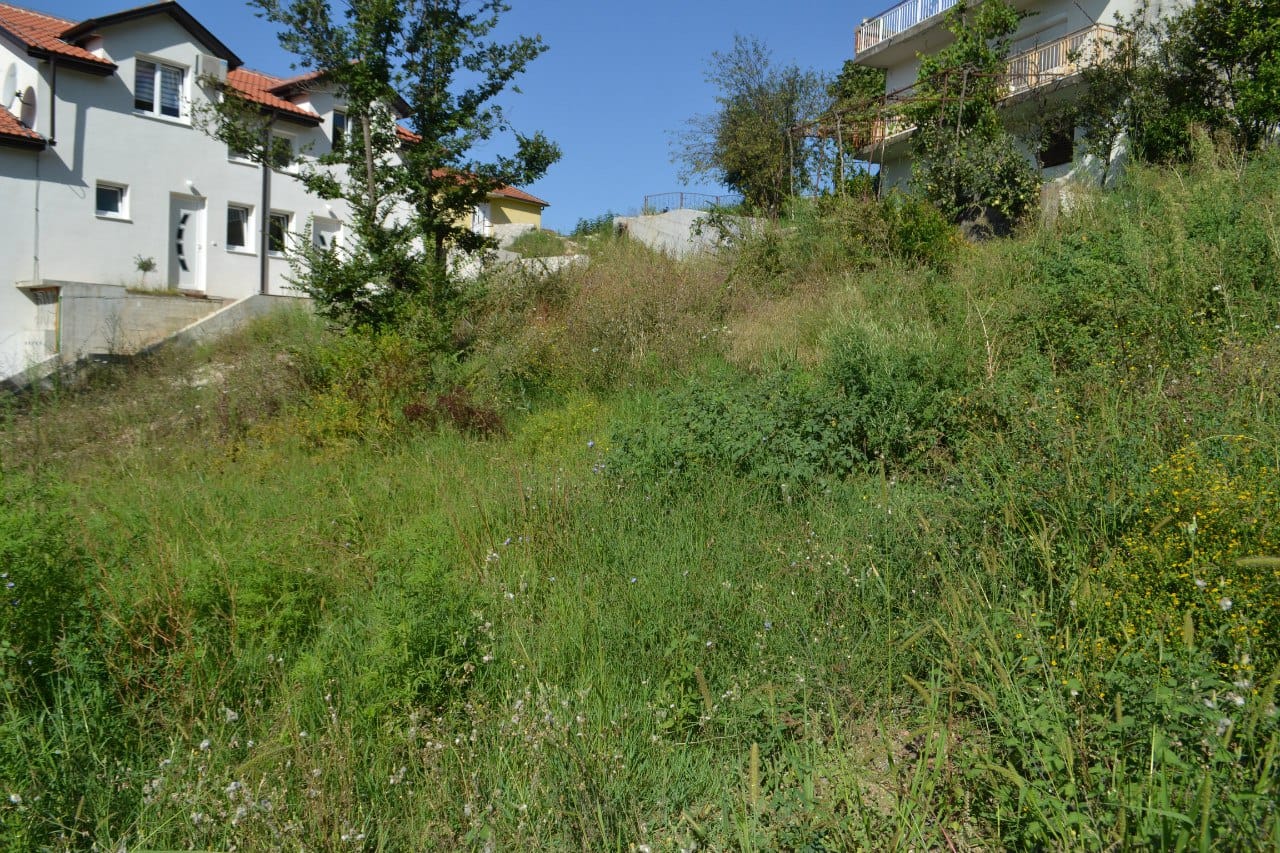 Baugrundstück in Herceg Novi, Montenegro: Blick auf das hügelige Gelände neben Wohnhäusern.