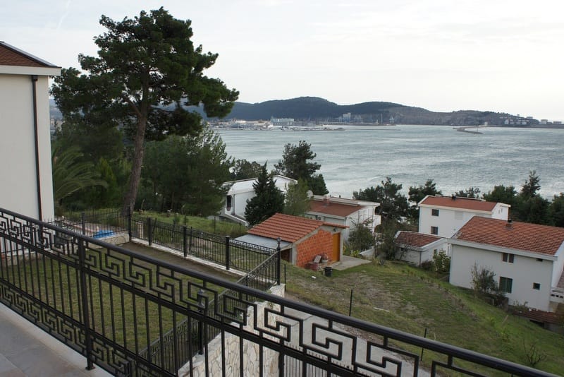 Pogled sa balkona kuće u Šušnju, Crna Gora: panorama mora, luke i zelenog brdovitog pejzaža sa privatnim vilama.