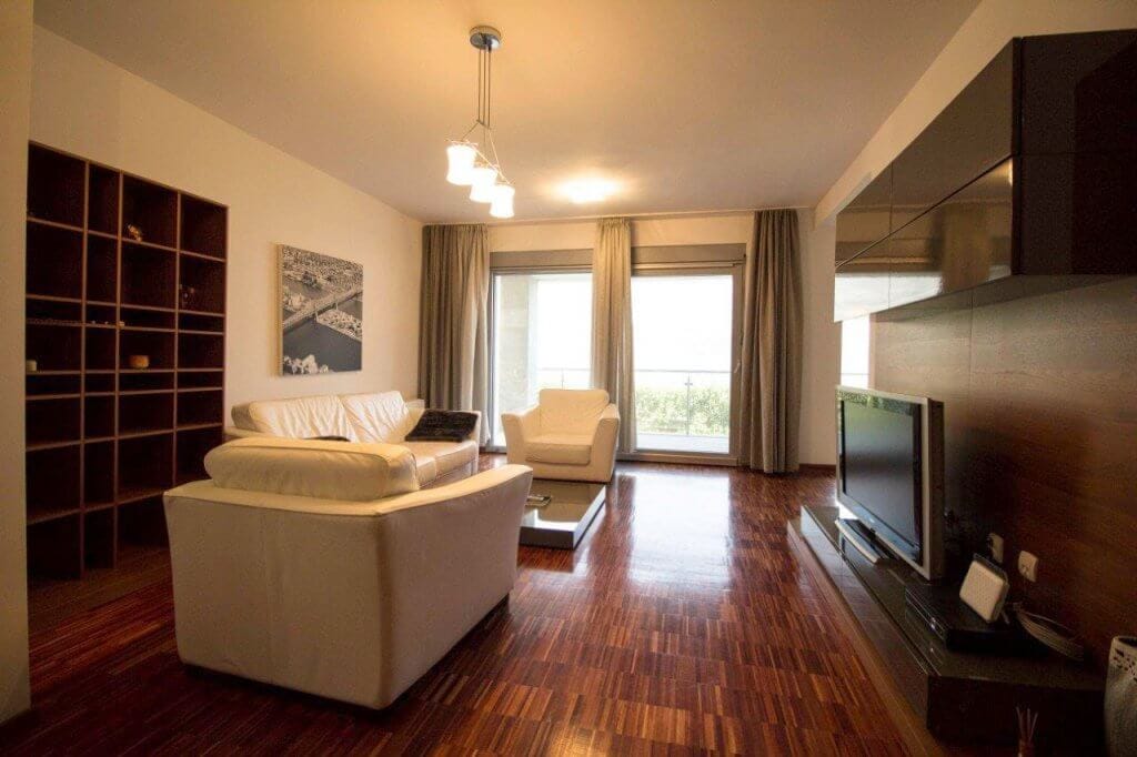 Modern living room with white furniture and parquet flooring in an apartment, Stoliv, Bay of Kotor, Montenegro.