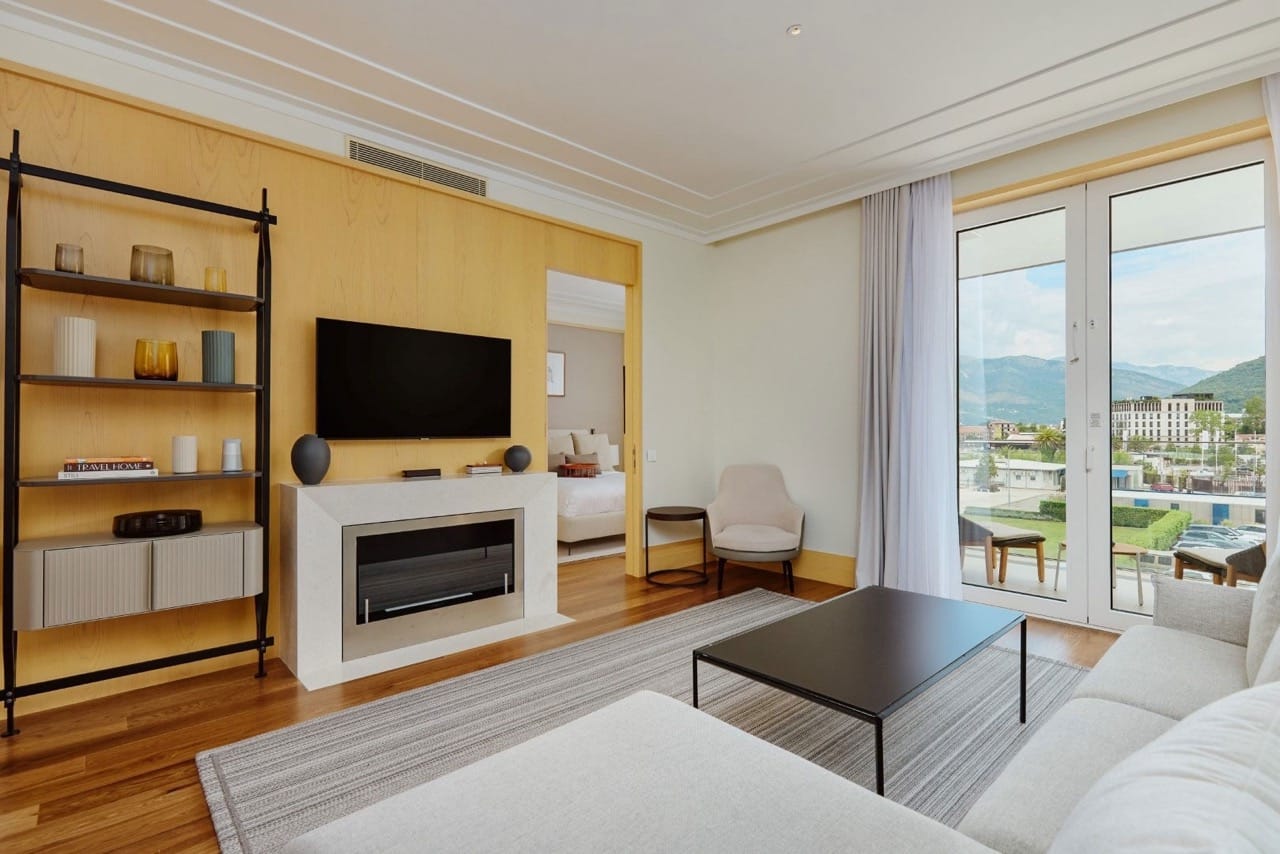 Dnevna soba u stanu Porto Montenegro, Tivat, Crna Gora: moderan enterijer sa kaminom, terasom i pogledom na planine.