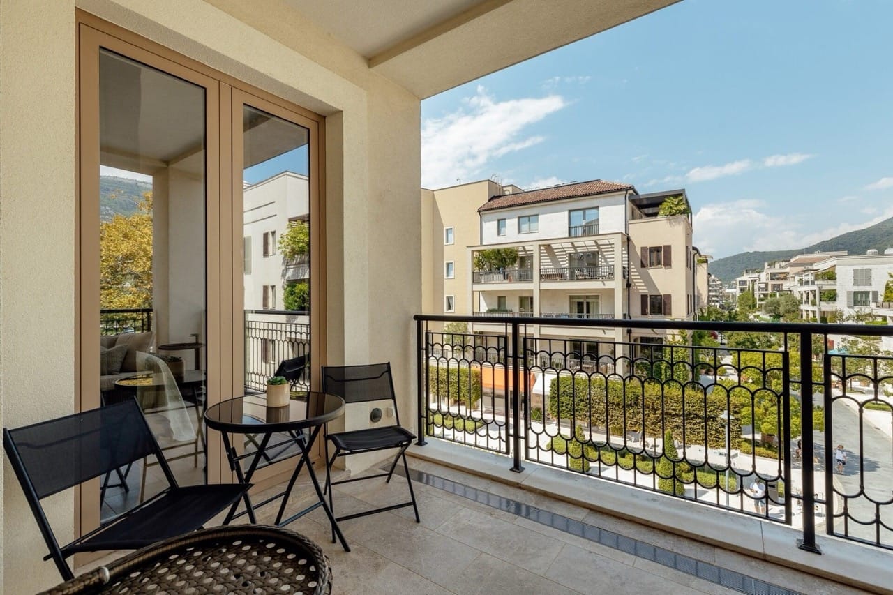 Ugodan balkon s nameštajem u elitnom stambenom kompleksu Porto Montenegro, Tivat, Crna Gora, s pogledom na uređeno dvorište.
