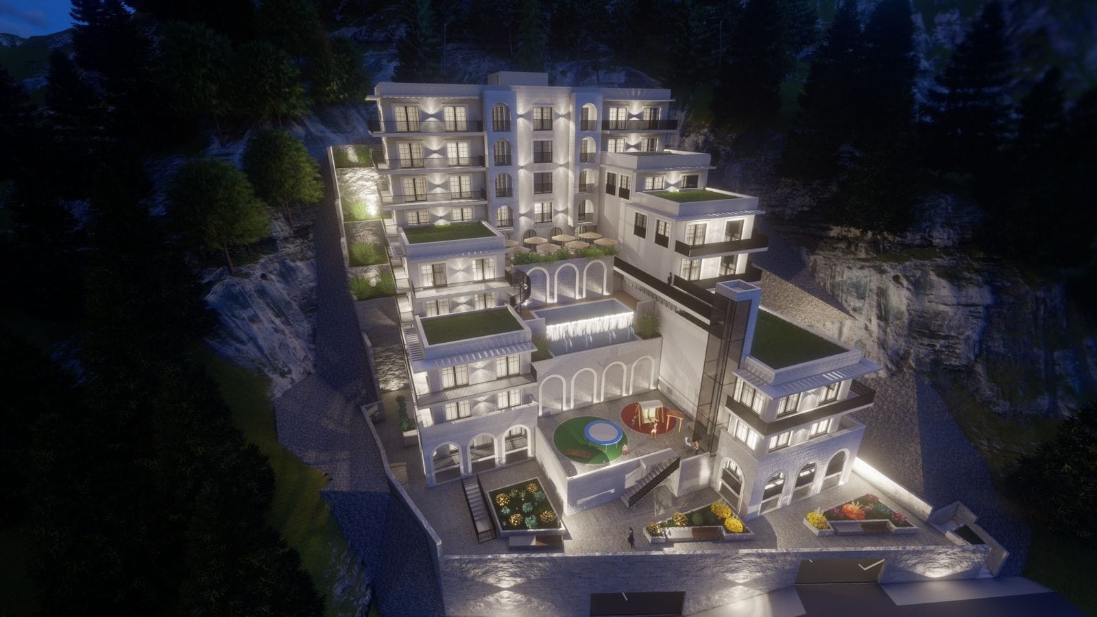 Night view of a residential complex in Budva, Montenegro: modern architecture, terraces, a swimming pool, and a playground.