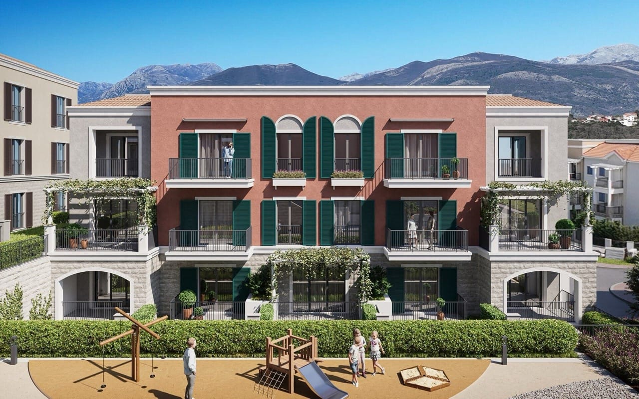 Façade du complexe résidentiel à Luštica Bay, Radovići, Monténégro : terrasses avec volets verts et aire de jeux pour enfants près de l’immeuble.