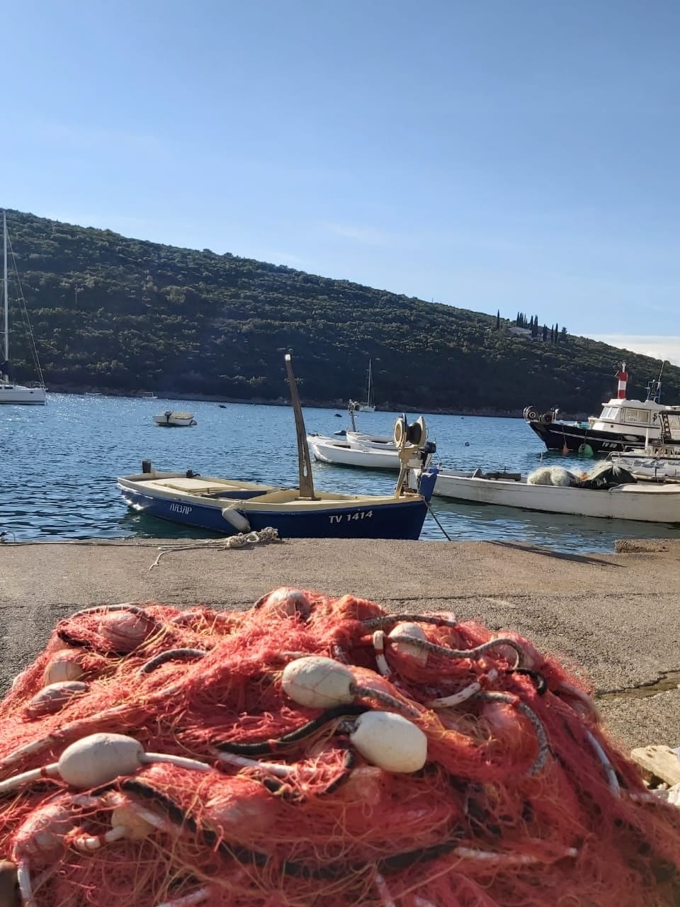 Sea view and fishing boats in Bigovo Bay, Montenegro, near Villa No. 2354, with fishing nets in the foreground.