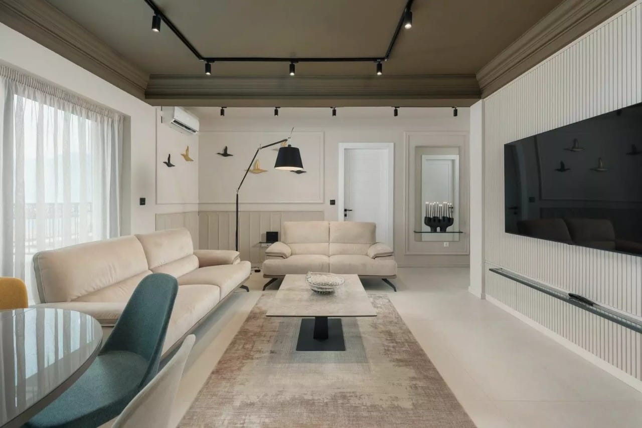 Modern living room with beige sofas and track lighting in an apartment, Dobrota, Montenegro.