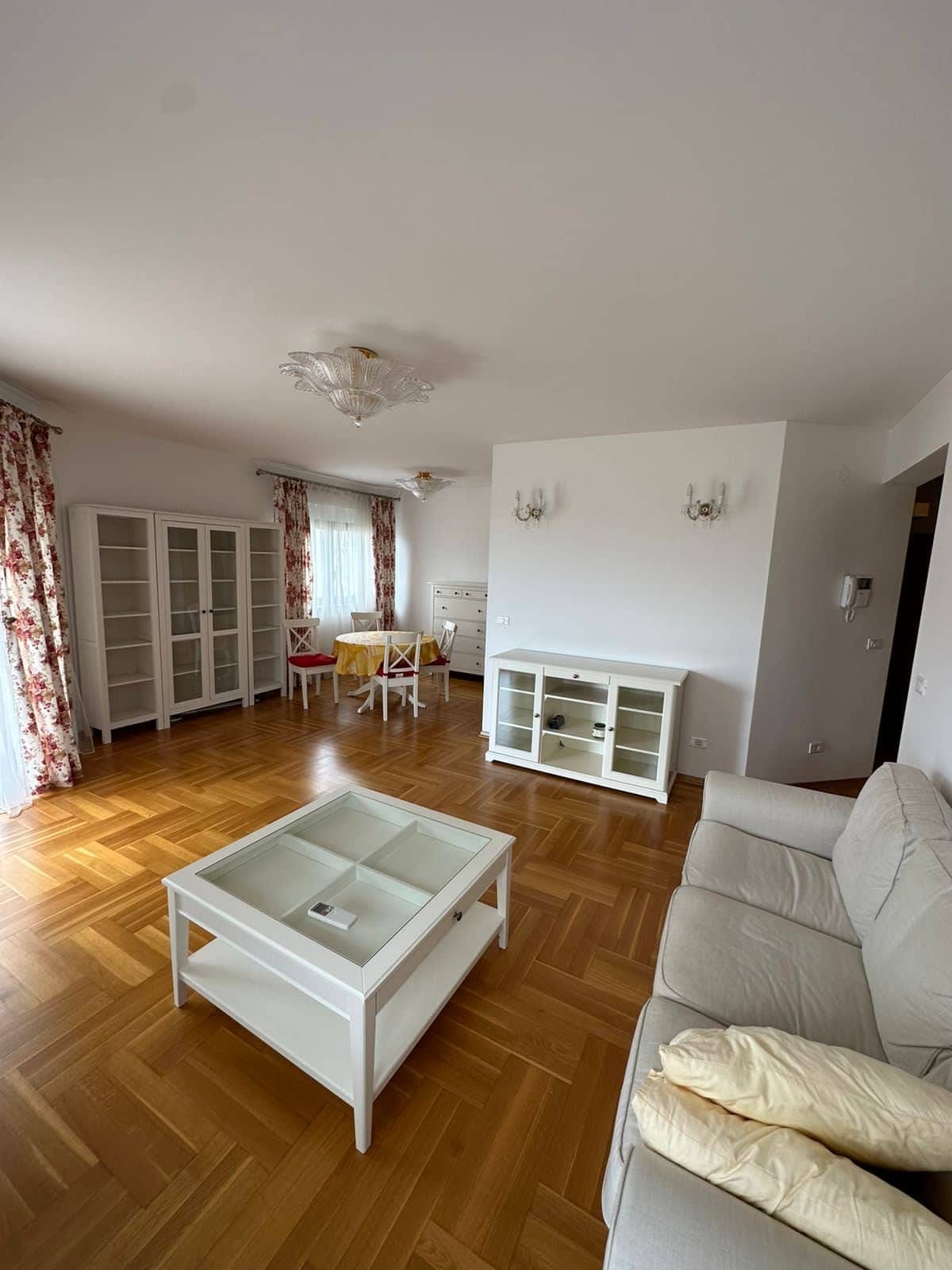 Bright living room with white furniture and parquet flooring in an apartment for sale in Bar, Montenegro.