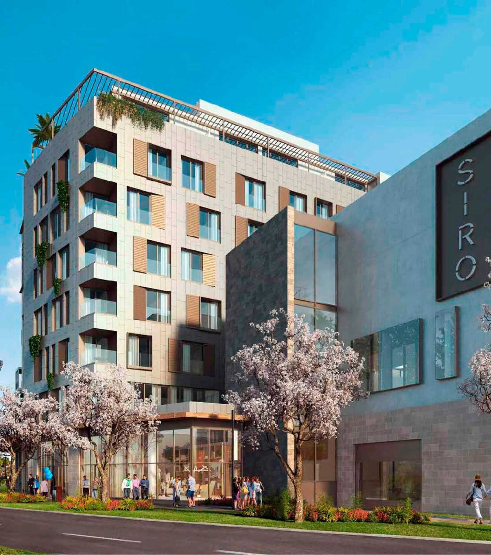Современный отель SIRO в Boka Place, Тиват, Черногория: фасад здания с панорамными окнами и цветущими деревьями.