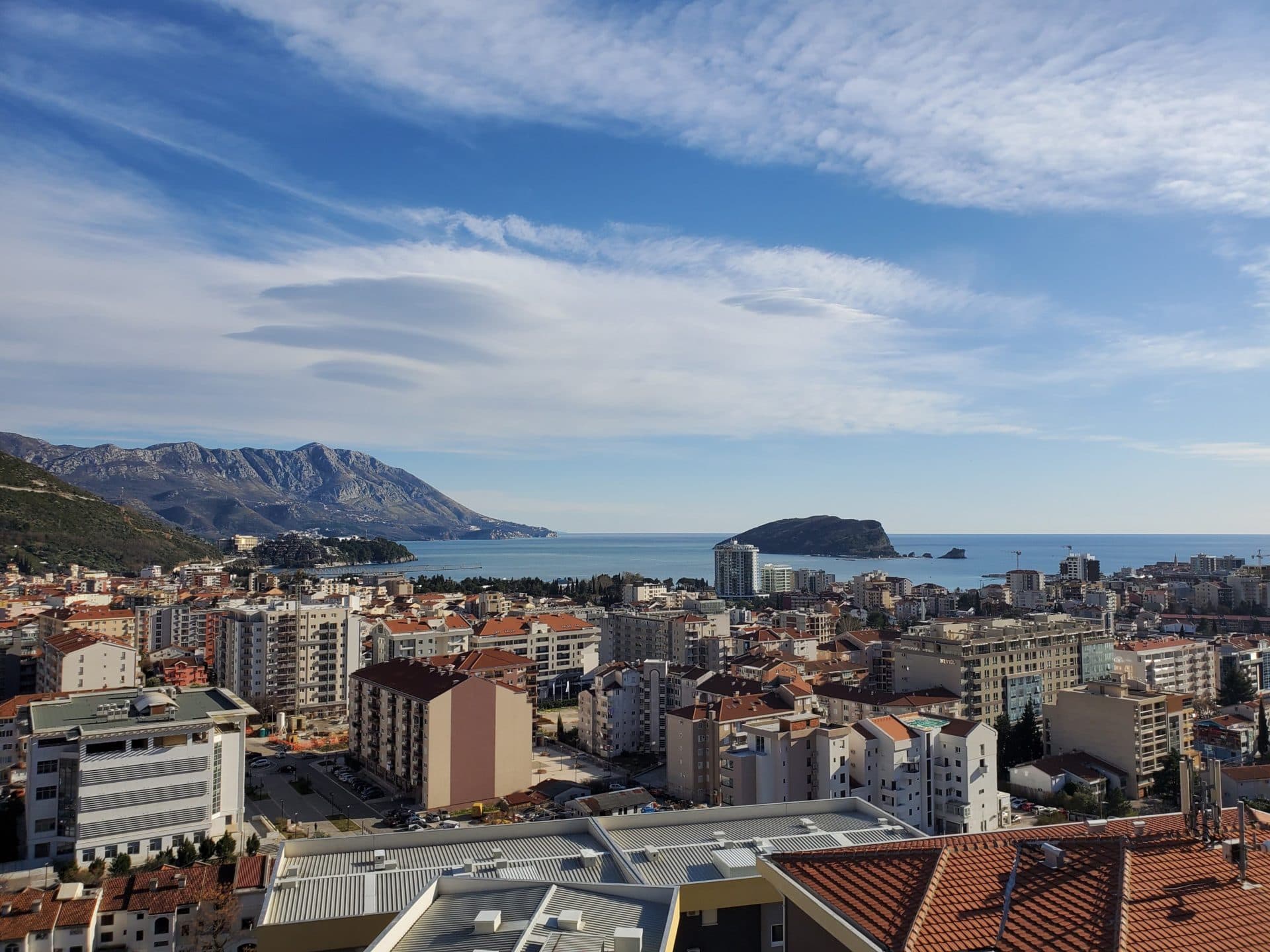 Vue panoramique sur la mer, l'île de Saint-Nicolas et les montagnes depuis la fenêtre d'un appartement à Budva, au Monténégro.
