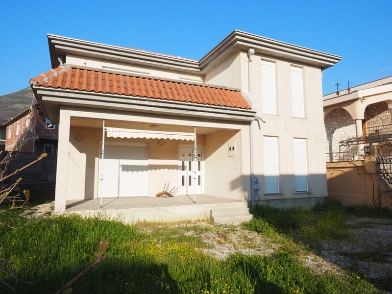 Two-story house with a terrace and tiled roof in Bar, Montenegro, front view and adjacent plot.