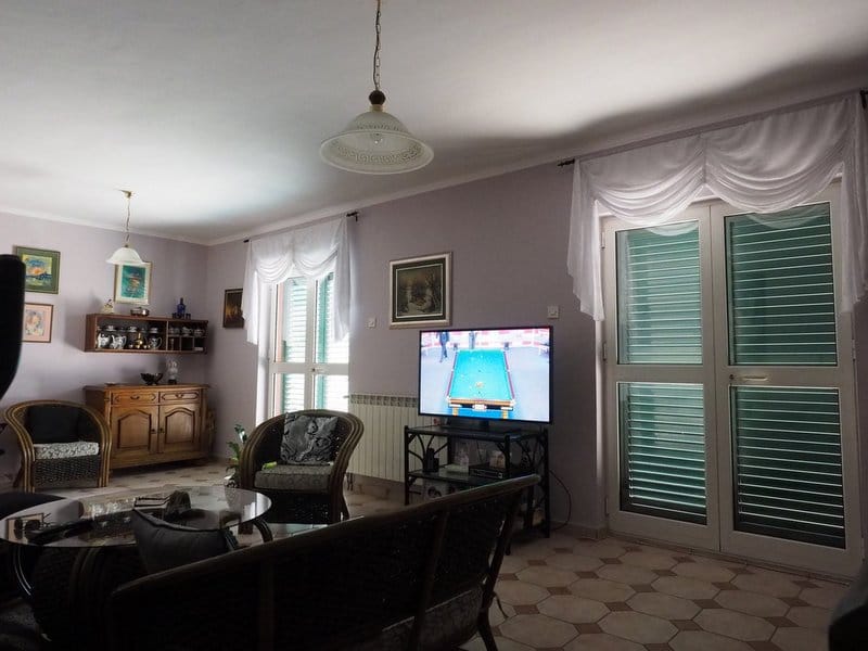 Cozy living room with wicker furniture and access to the terrace in a villa, Dobrota, Montenegro.