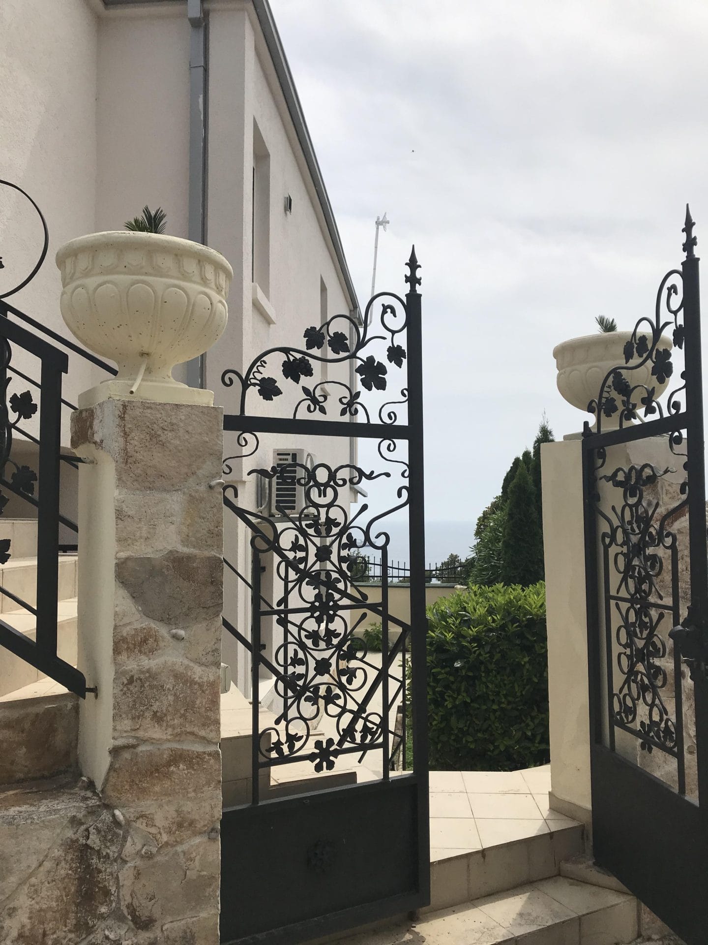 Kovana kapija i kameno stepenište kuće u Baru, Crna Gora: pogled na dvorište i baštu.