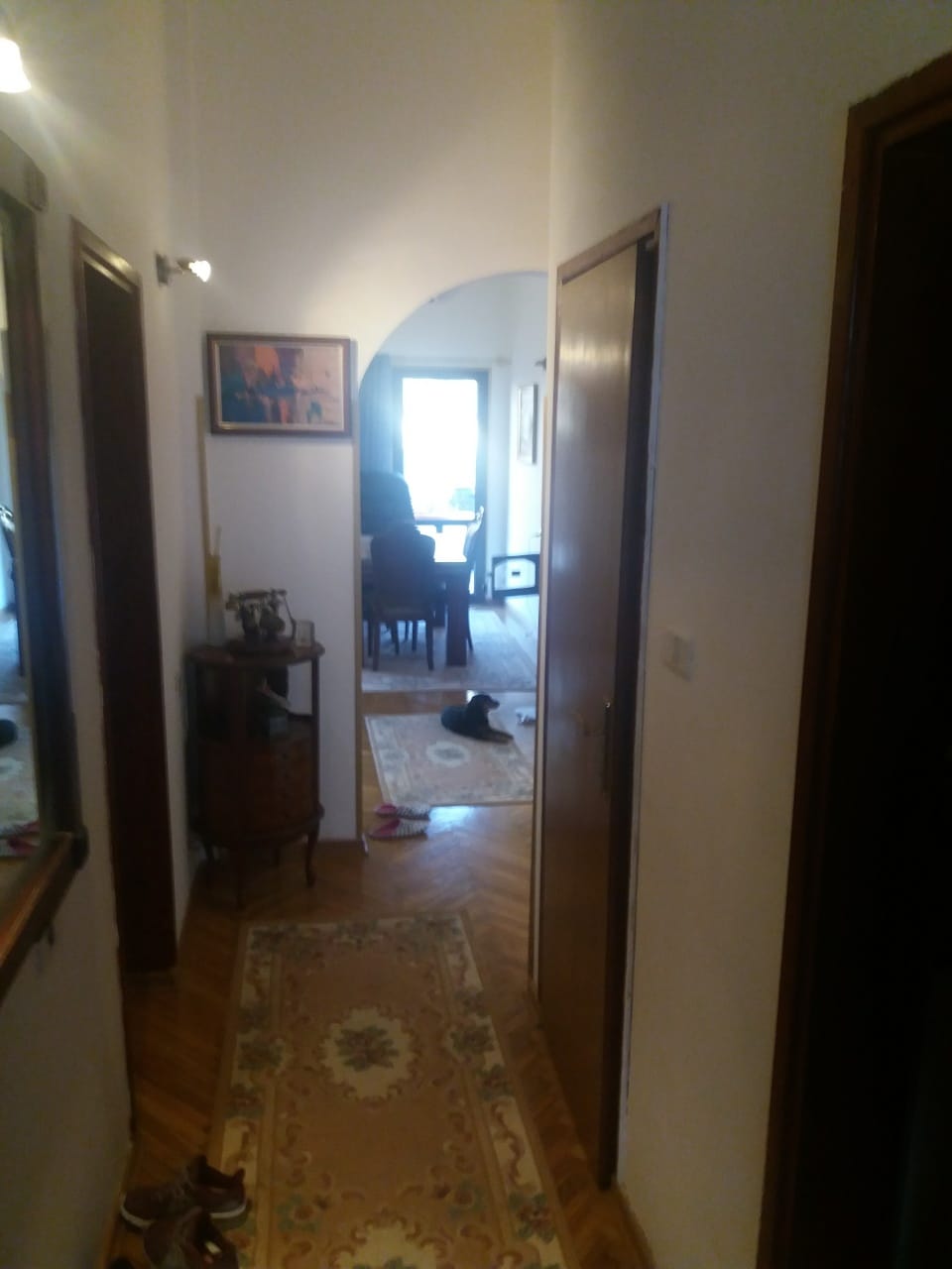 Прихожая с паркетом и арочным проходом в гостиную в доме, город Муо, Черногория.