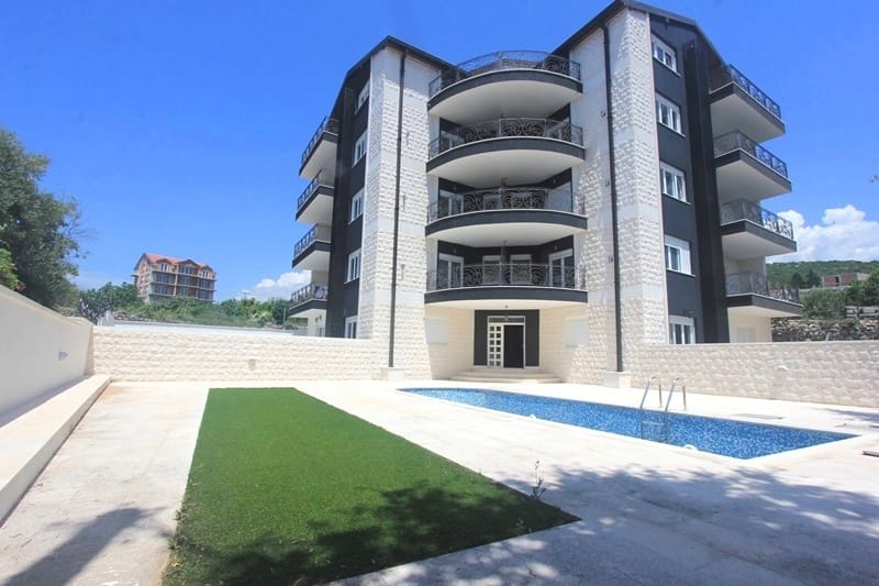 Современный жилой дом в Крымовице, Черногория, с открытым бассейном, террасами и каменной отделкой фасада.