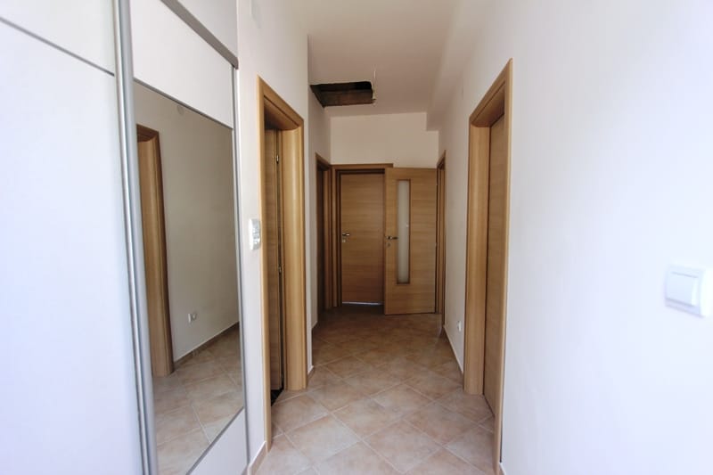 Bright hallway with a mirrored wardrobe and interior doors in a house for sale, Baošići, Montenegro.