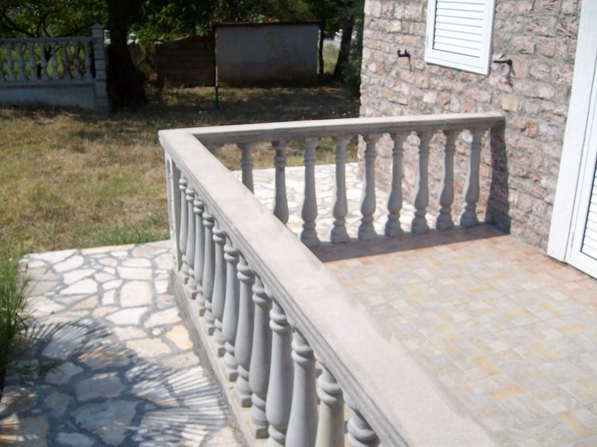 Otvorena terasa sa kamenim balustradama i pločastom oblogom na vili u gradu Bar, Crna Gora.
