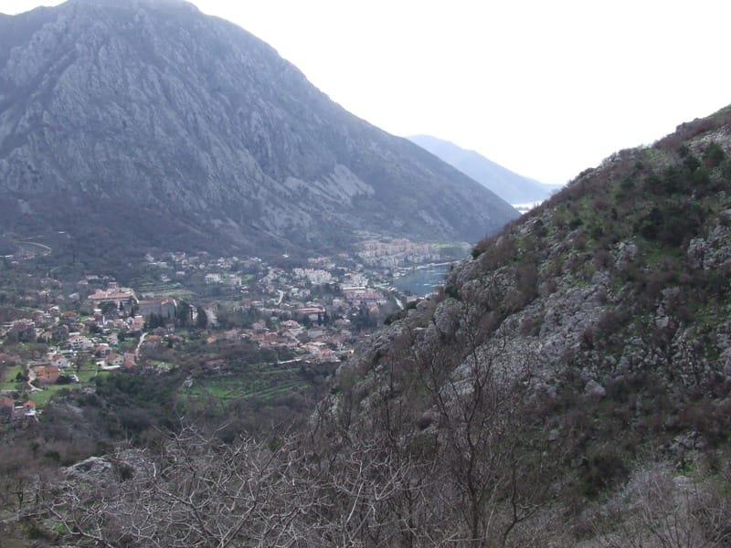Panoramic view of the town of Risan and the Bay of Kotor in Montenegro from a mountain plot, featuring views of the mountains and the sea.