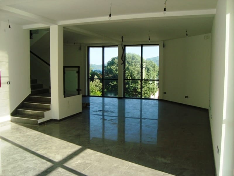 Spacious commercial space in Baošići, Montenegro: bright living room with panoramic windows and a staircase.