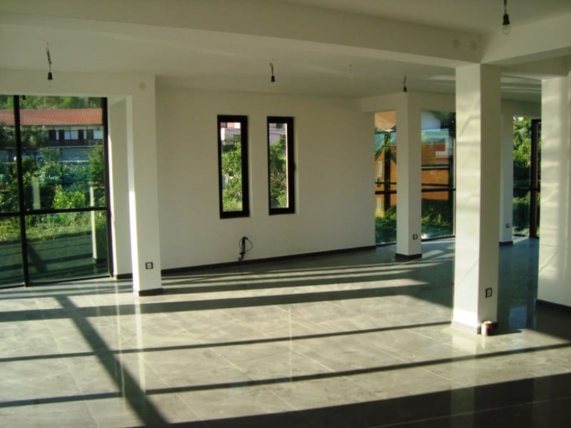 Spacious commercial space in Baošići, Montenegro: a bright living room with panoramic windows and tiled flooring.