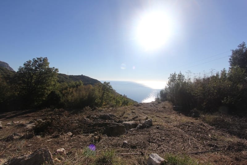 Land plot in Sveti Stefan, Montenegro, with panoramic views of the Adriatic Sea and hilly landscape.