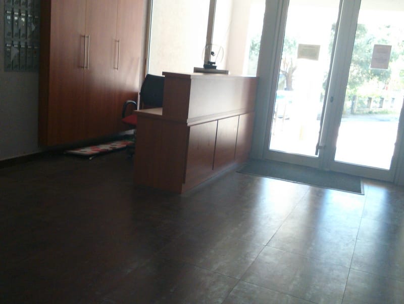 Recepcijski pult i poštanski sandučići u holu stambenog kompleksa u Budvi, Crna Gora. Moderan enterijer sa panoramskim prozorima.