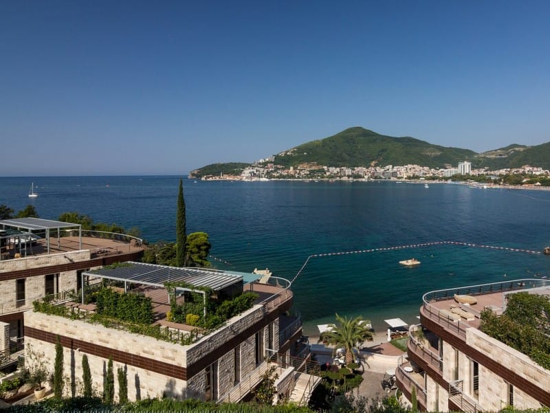 Вид на море и пляж из элитного комплекса Dukley Gardens в Будве, Черногория: террасы с озеленением и современная архитектура.