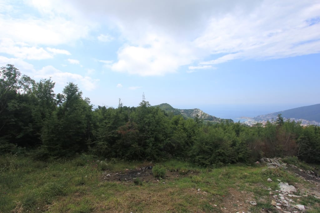 Land plot in Markovichi, Montenegro: panoramic view of the mountains, green forest, and the Adriatic Sea in the distance.