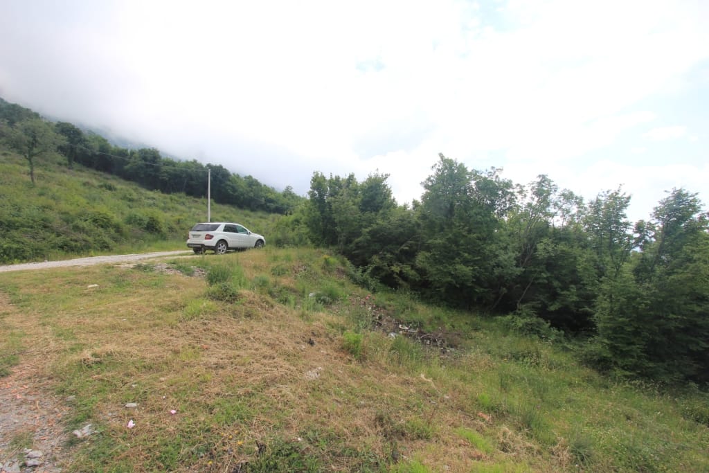 Land plot in Markovichi, Montenegro: view of hilly terrain, forest area, and access road.