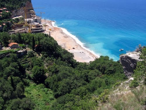 View of the property under construction and the beach in Perazića Do, Montenegro: a seaside plot of land with a panoramic view of the coast.